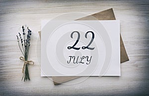 July 22. 22th day of the month, calendar date.White blank of paper with a brown envelope, dry bouquet of lavender flowers on a