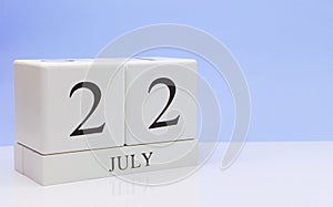July 22st. Day 22 of month, daily calendar on white table with reflection, with light blue background. Summer time, empty space