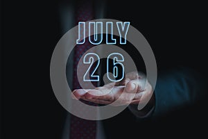 july 26th. Day 26 of month, announcement of date of business meeting or event. businessman holds the name of the month and day on