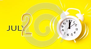 July 2nd. Day 2 of month, Calendar date. White alarm clock with calendar day on yellow background. Minimalistic concept of time,