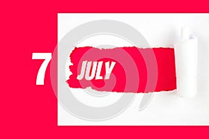 July 7th. Day 7 of month, Calendar date. Red Hole in the white paper with torn sides with calendar date. Summer month, day of the