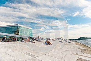 July 26, 2013. Day view of the Opera house and promenade in Oslo, Norway. Tourists enjoy the view of the fjord. Tourists near the