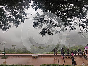 July 6, 2019- Karnataka, India: A landscape view of Raja`s Seat park filled with fog in Coorg, Karnataka, India. People spectatin