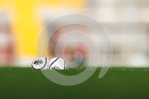 July 28th, 2021, Cork, Ireland - two size 5 official hurling championship sliotars lie in the grass with an out of focus backgroun