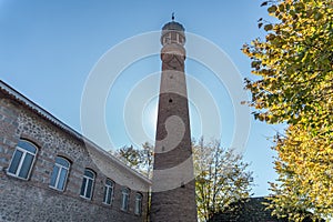 Juma Mosque minaret against solid blue skey.