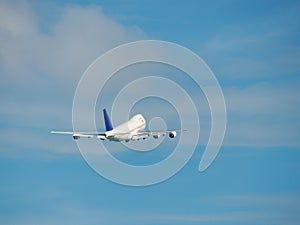 Jumbo airplane is taking off into a blue sky