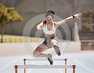 Jump, athlete and hurdle black woman in sports race, competition or training at stadium with energy, power and body
