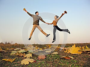 Jump couple autumn leaves