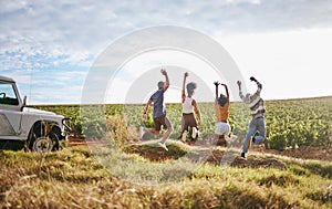 Jump, freedom and friends in a field in nature while on a summer road trip vacation in the countryside. Group, travel