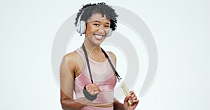 Jump rope, fitness and woman with headphones on a white background for workout, training and exercise. Happy, sports and