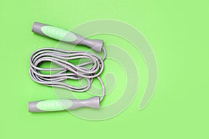 Jump rope on green background, top view