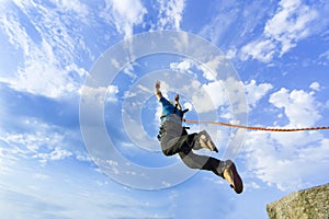 Jump rope from a high rock in the mountains.