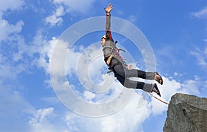 Jump rope from a high rock in the mountains.