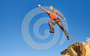 Jump rope from a high rock in the mountains