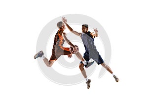 Dynamic portrait of two basketball playera in motion, in a jump, throwing ball into basket isolated over white studio photo