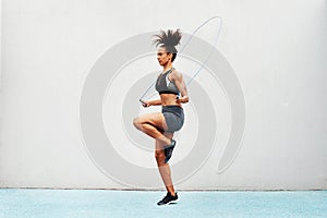 Jump, skipping rope and training with woman in stadium for sports, workout practice and cardio. Performance, health and