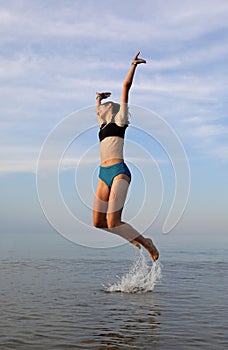Jump from water of a slender girl symbol of happiness and jo