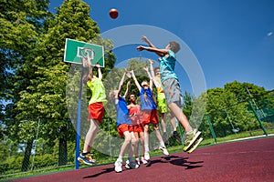 Jumping for ball teenagers playing basketball game