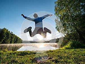 Jumping boy celebrate freedom and make fun at lake