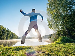 Jumping boy celebrate freedom and make fun at lake