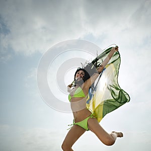 Jumping with Brazil flag on beach