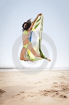 Jumping with Brazil flag on beach