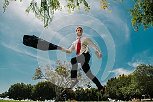 Jumping businessman in park. Fast business concept.
