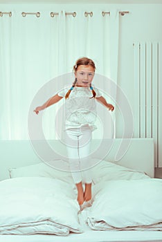 Jumping child girl in bed
