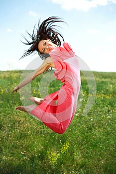 Jumping and flying graceful girl on the background of blue sky