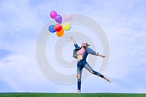 The jumping girl holds a ball of light color on a bright sky background