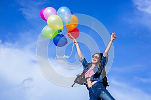 The jumping girl holds a ball of light color on a bright sky background