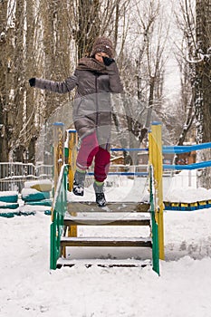 Jumping girl on a winter playground