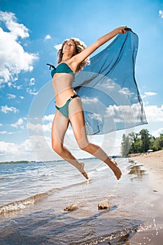 Jumping happy girl on the beach, fit sporty healthy body in bikini