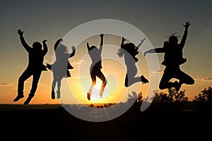 Jumping happy people against the backdrop of sunset. Success, happiness. AI generative