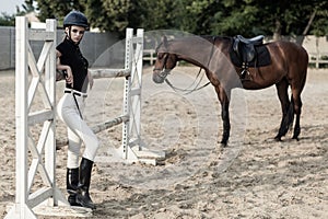 Jumping over obstacles. Beautiful woman standing near brown hour