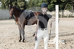 Jumping over obstacles. Horserace concept. Beautiful woman near