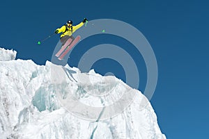 A jumping skier jumping from a glacier against a blue sky high in the mountains. Professional skiing