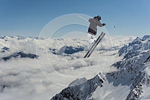 Jumping skier in mountains. Extreme sport, freeride.
