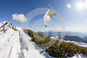 Jumping skier in mountains. Extreme sport, freeride.