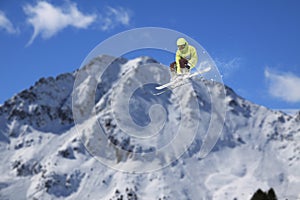 A jumping skier in the mountains. Mountain ski, winter extreme sport.