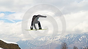 Jumping snowboarder grab snowboard on sky background, Sochi, Russia