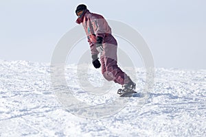 Jumping snowboarder from hill in winter