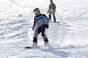 Jumping snowboarder from hill in winter