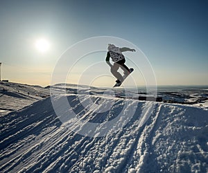 Jumping snowboarder in mountains