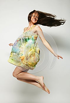 Jumping woman. Happy emotional girl. Long hair in motion.Studio