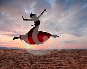 Jumping woman at sunset