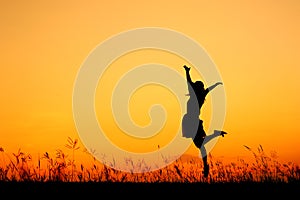 Jumping woman and sunset silhouette