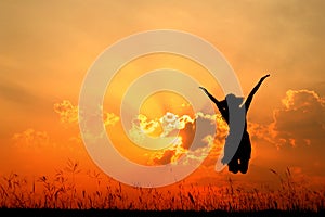 Jumping woman and sunset silhouette