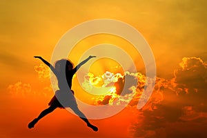 Jumping woman and sunset silhouette