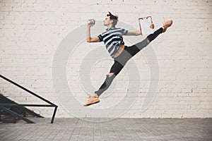 Jumping young buinessman in front of buildings, on the run in jump high